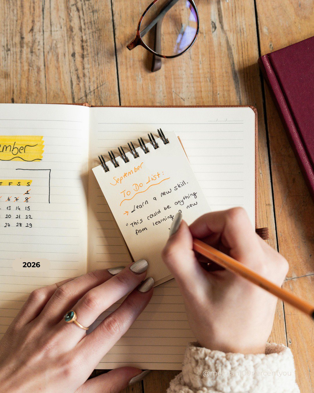 woman writing a to do list with a calendar next to her and taking time for herself